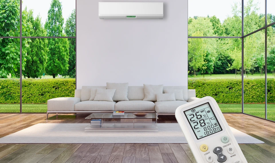 Intérieur moderne avec canapé gris face à baies vitrées donnant sur jardin verdoyant