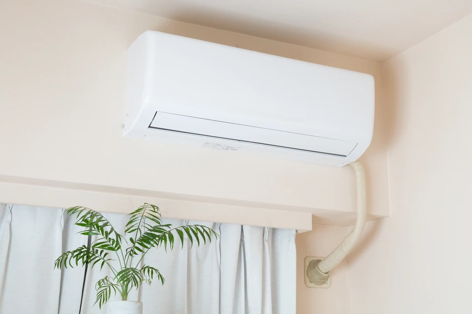 Extérieur résidentiel moderne avec unité de climatisation ou pompe à chaleur installée sur socle béton